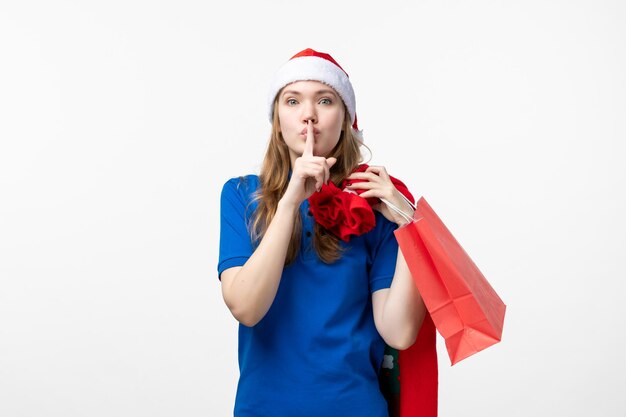 Front view of female courier holding present on white wall