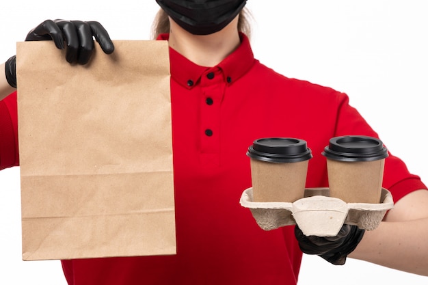 Вид спереди курьер женского пола в красной рубашке andb не хватает glvoes, держа кофейные чашки и пакет с едой