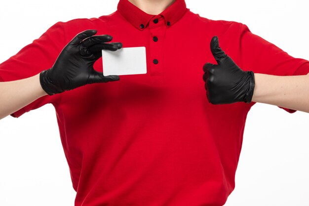 Вид спереди курьер женского пола в красной рубашке и черных перчатках держит белую карточку на белом