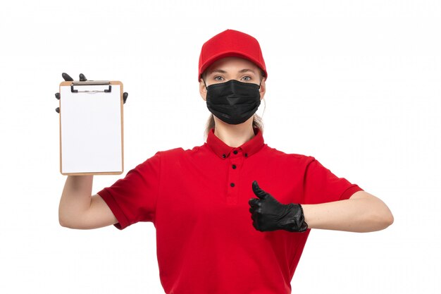 赤いシャツの赤い帽子の黒い手袋と白のメモ帳を保持している黒いマスクの正面女性宅配便
