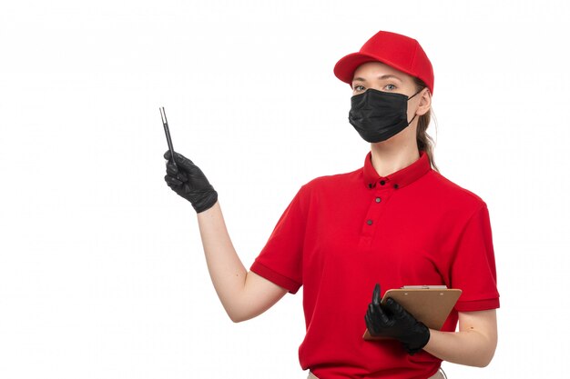 A front view female courier in red shirt red cap black gloves and black mask holding pen and paper on white