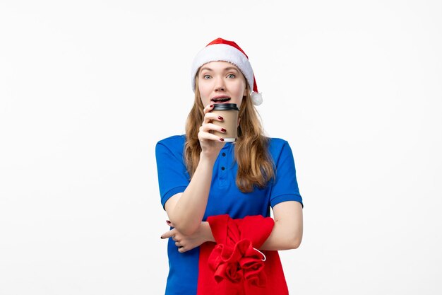 Front view of female courier with coffee cup on a white wall