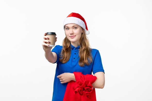 Front view of female courier with coffee cup on white wall