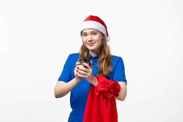 Front view of female courier with coffee cup on white wall