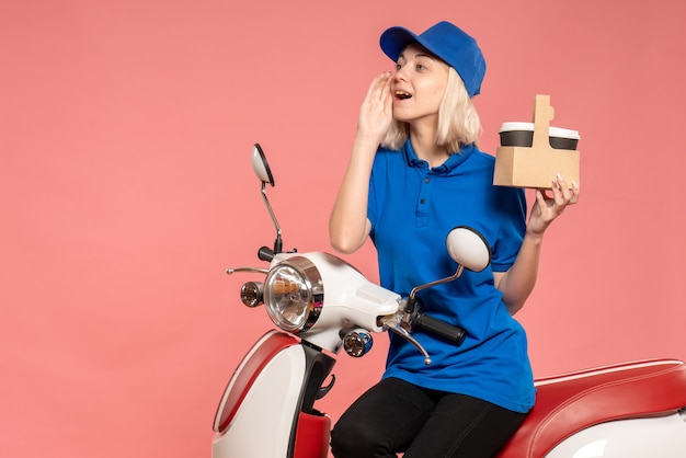 Corriere femminile vista frontale con tazze di caffè sul lavoro di operaio colore rosa servizio di consegna lavoro