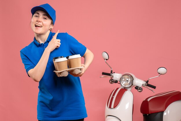 Front view female courier with delivery coffee on pink work delivery job service worker bike