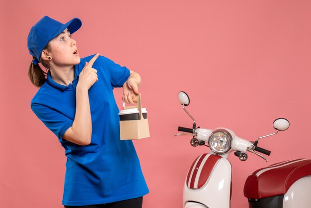 Front view female courier with delivery coffee on pink work delivery worker woman bike uniform job