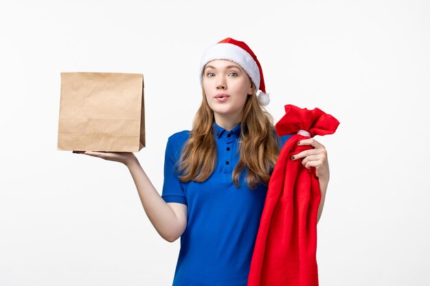 Front view of female courier with delivery package on a white wall