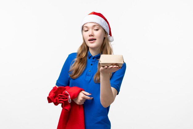 Front view of female courier with food delivery on a white wall