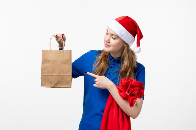 Front view of female courier with holiday present on white wall