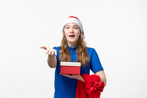 Front view of female courier with holiday present on white wall