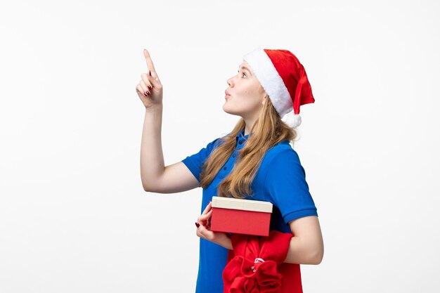 Front view of female courier with holiday present on white wall