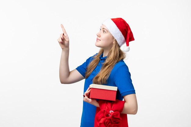 Front view of female courier with holiday present on white wall