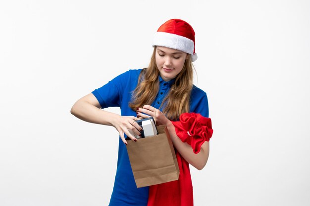 Front view of female courier with holiday present on white wall