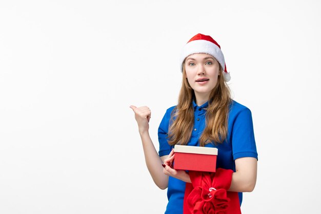 Front view of female courier with holiday present on white wall