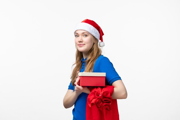 Front view of female courier with holiday present on white wall