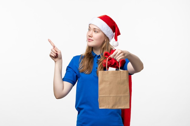 Front view of female courier with holiday present on white wall