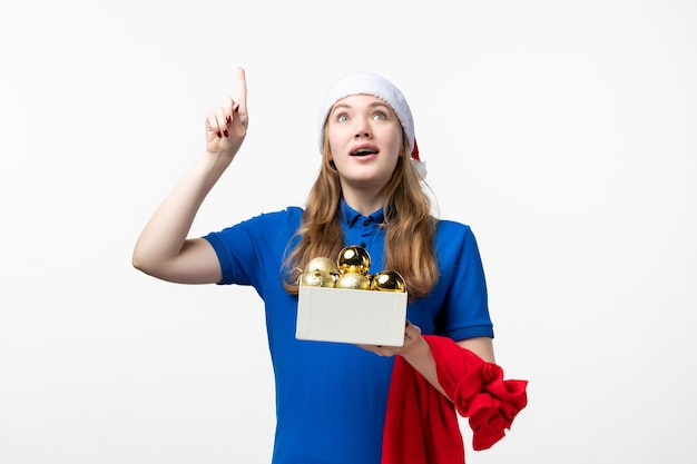 Front view of female courier with holiday toys on white wall