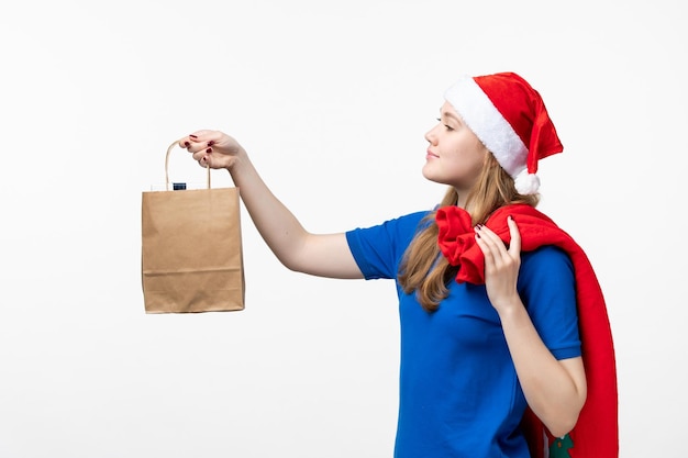 Front view of female courier with little present on a white wall