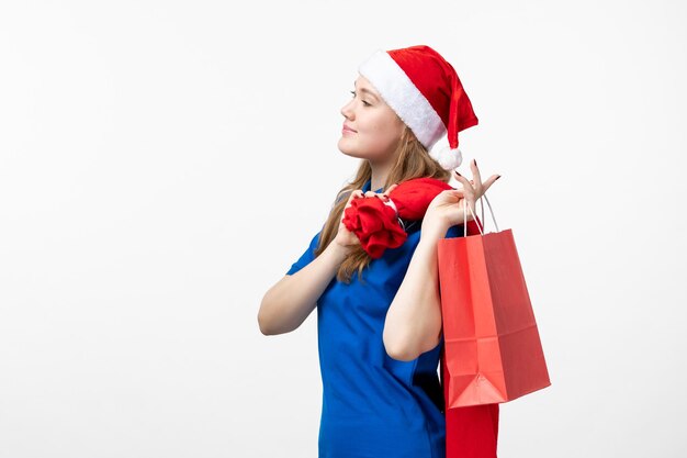 Front view of female courier with little present on white wall