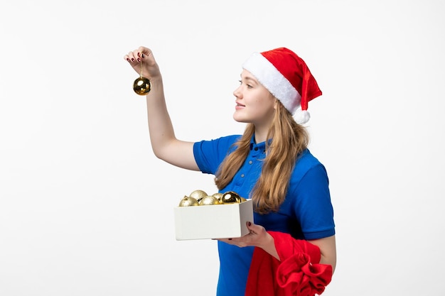 Front view of female courier with plastic toys on white wall