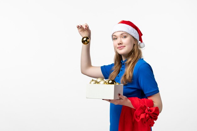 Front view of female courier with plastic toys on white wall