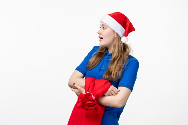 Front view of female courier with present bag on white wall