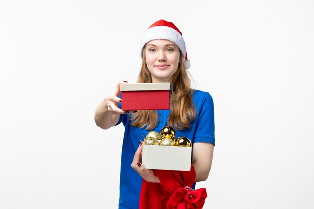 Front view of female courier with present and toys on the white wall