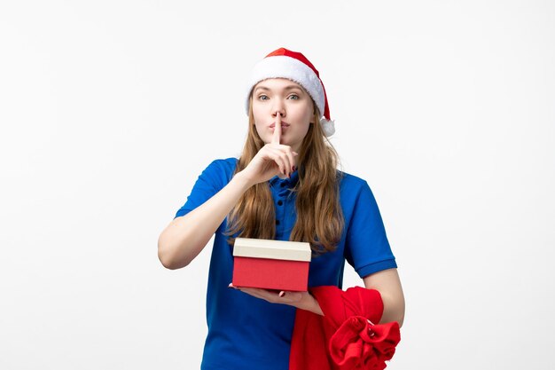 Front view of female courier with present on white wall