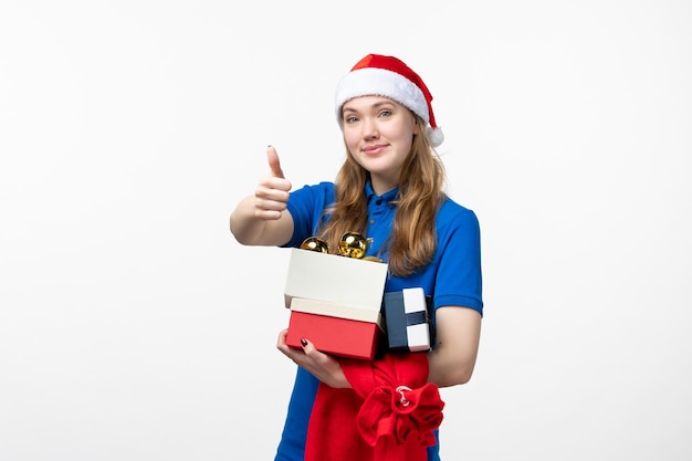 Front view of female courier with presents and toys on white wall