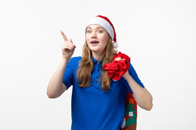 Front view of female courier with red present bag on a white wall