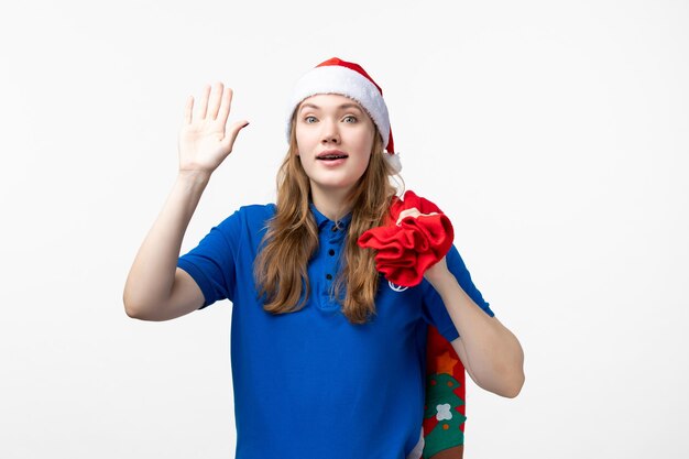 Front view of female courier with red present bag on the white wall