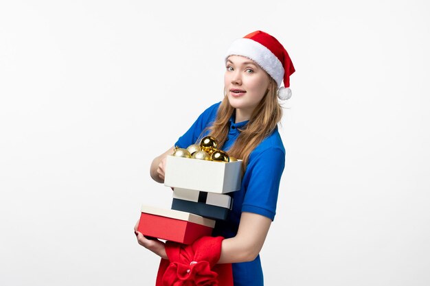 Front view of female courier with toys and presents on white wall