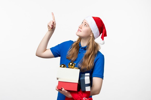 Front view of female courier with toys and presents on white wall