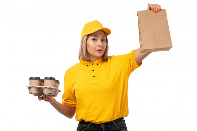 黄色のシャツイエローキャップホワイトの持株コーヒーカップと食品パッケージを笑顔で正面の女性宅配便