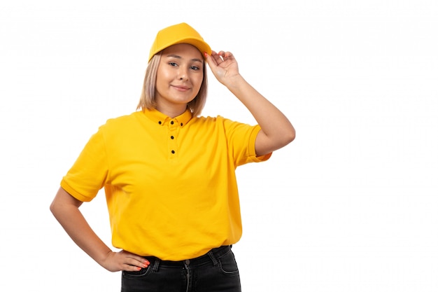 A front view female courier in yellow shirt yellow cap smiling on white