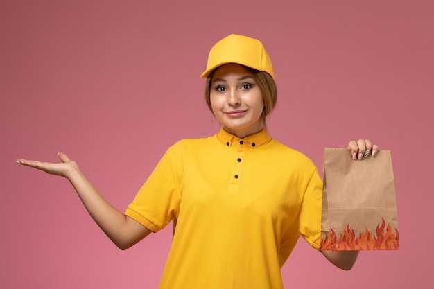분홍색 배경 유니폼 배달 작업 색상에 음식 패키지를 들고 노란색 유니폼 노란색 케이프 전면보기 여성 택배