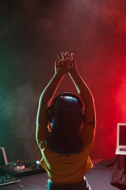 Front view female dj with hands raised above head