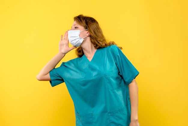 Front view female doctor calling in mask on yellow space