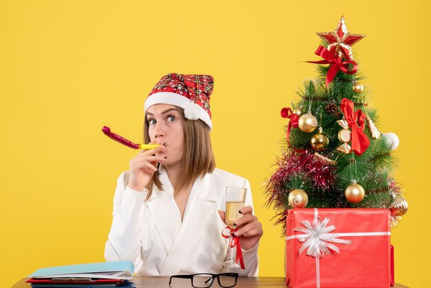 Front view female doctor celebrating xmas with champagne