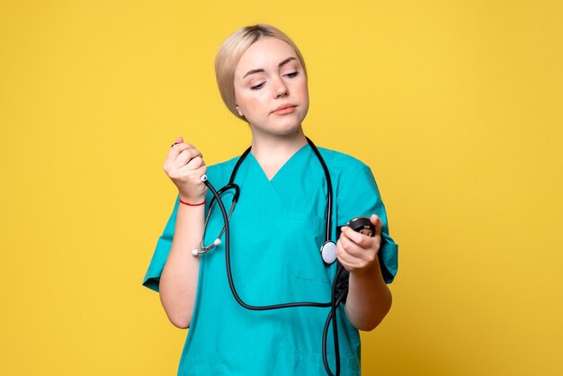 Front view female doctor checking her pressure, ambulance hospital nurse health covid-19 virus medic