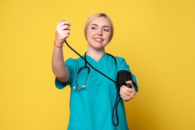 Front view female doctor checking her pressure, health medic covid-19 hospital nurse virus ambulance