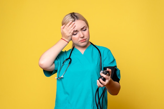 Front view female doctor checking her pressure, medic covid-19 hospital nurse virus ambulance