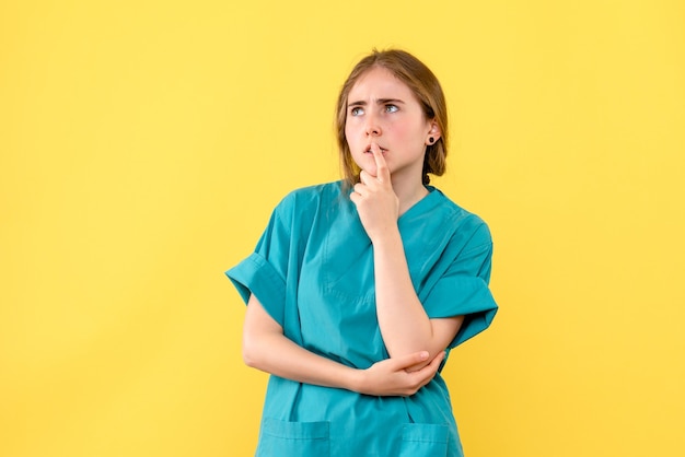 Front view female doctor deeply thinking on yellow background medic emotion hospital health virus