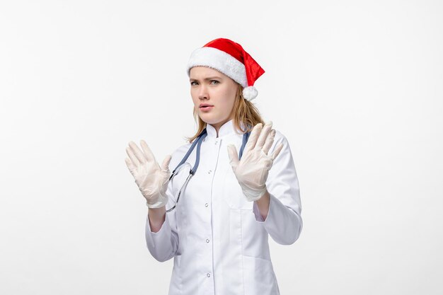 Front view of female doctor displeased on white wall