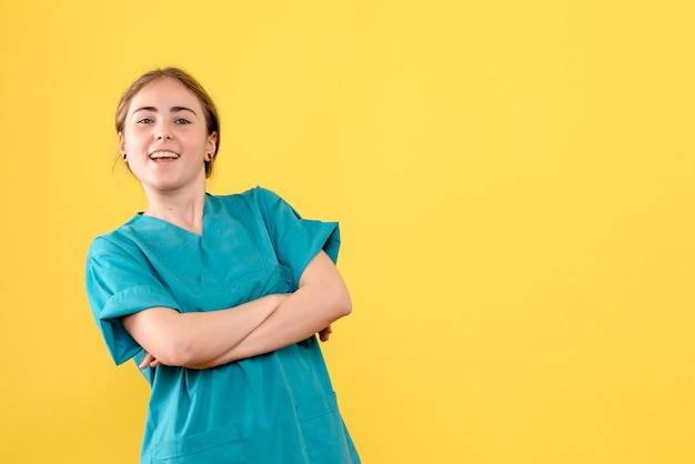 Foto gratuita medico femminile di vista frontale eccitato sull'emozione del virus dell'ospedale di salute del medico del fondo giallo chiaro