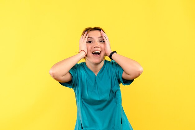 Front view female doctor excited on a yellow space