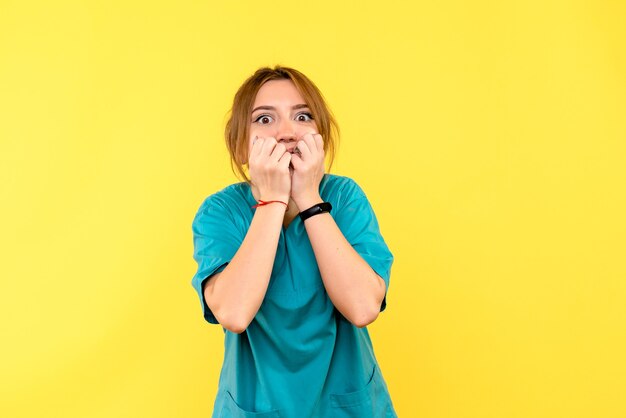 Front view female doctor feeling scared on yellow space