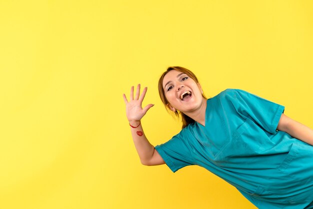 Front view female doctor greeting on yellow space