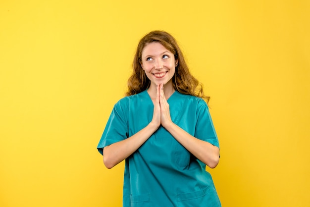 Free photo front view female doctor happily dreaming on yellow space